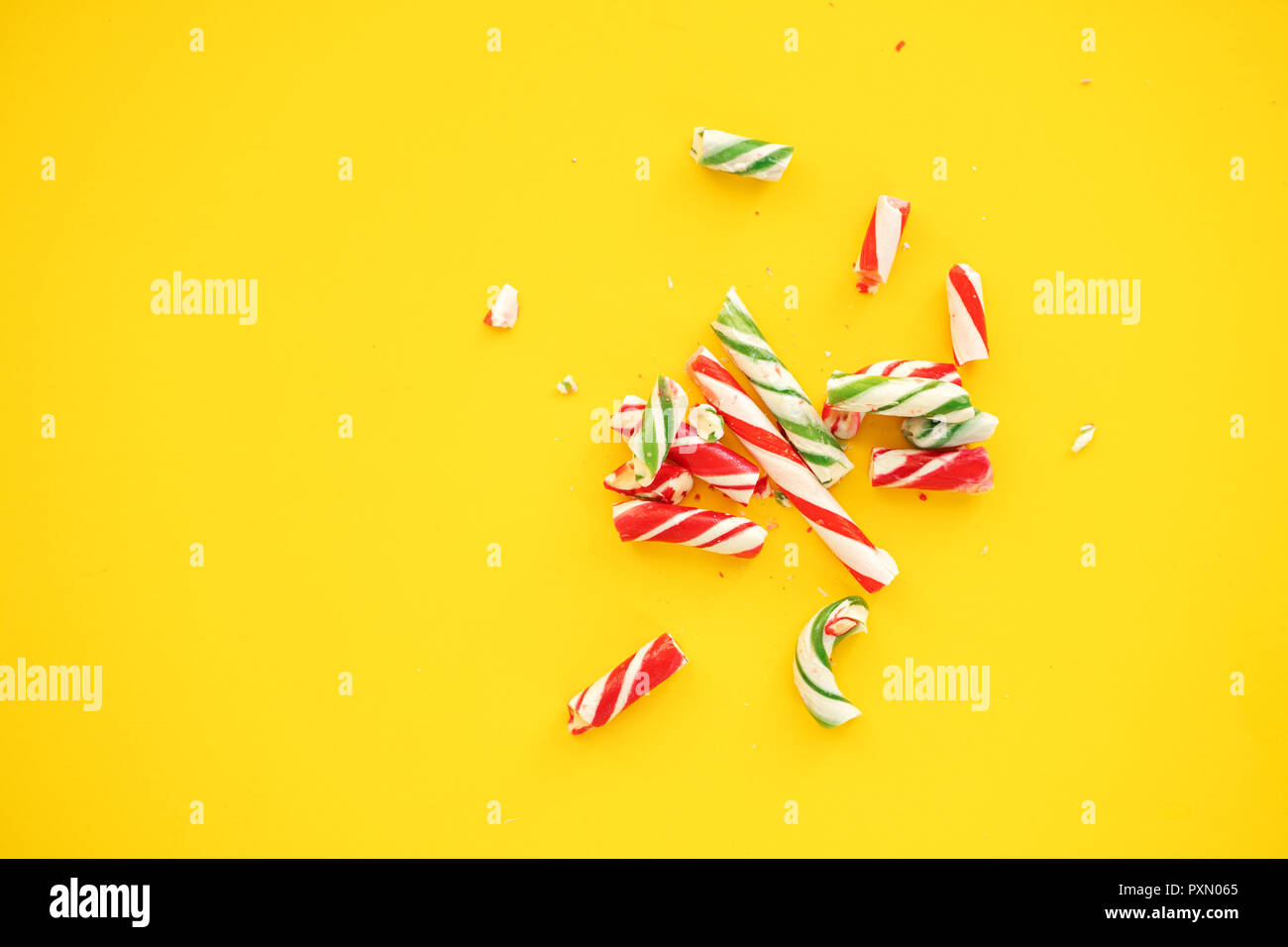 broken candy cane on yellow paper background Stock Photo - Alamy
