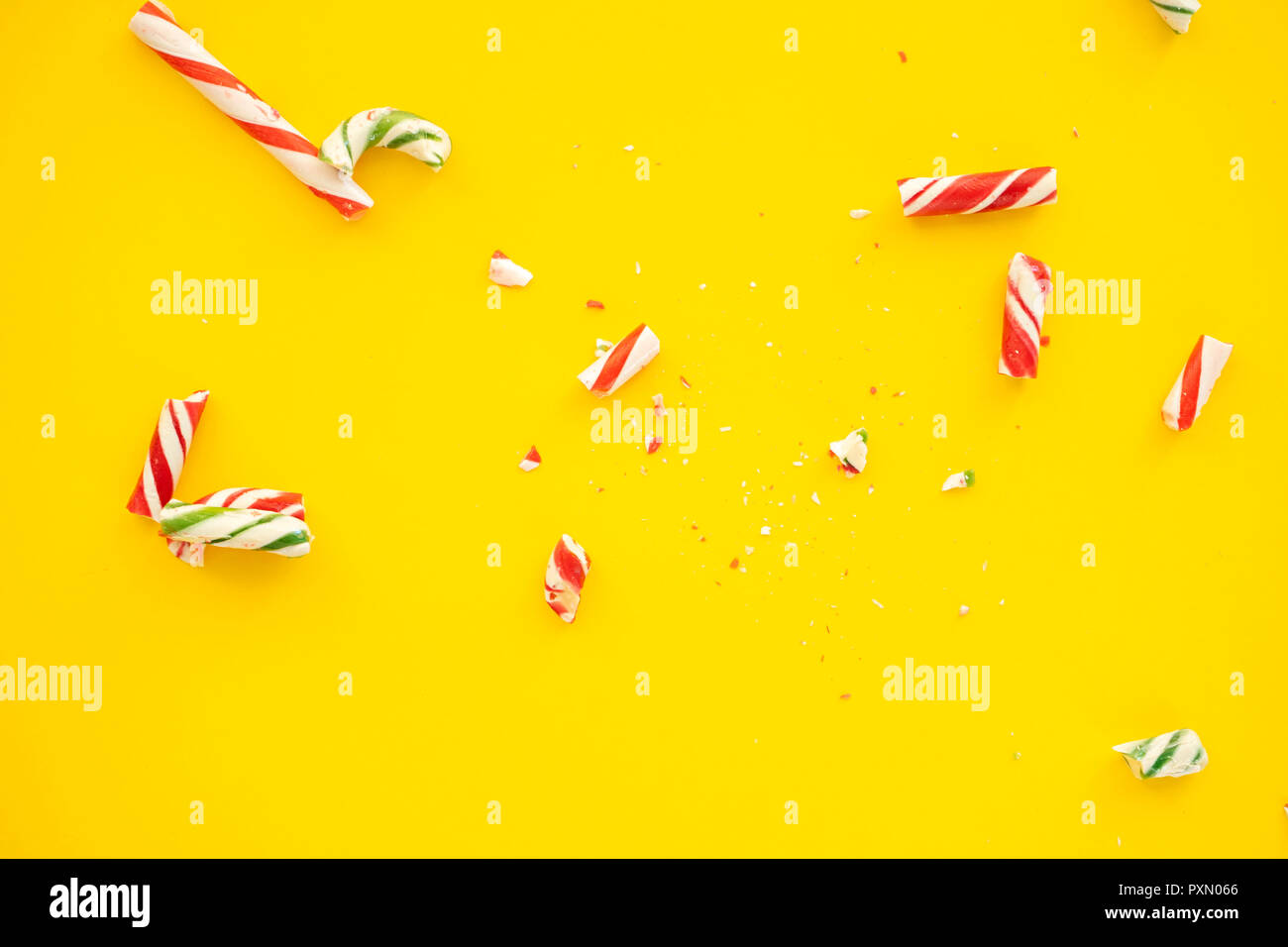 broken candy cane on yellow paper background Stock Photo - Alamy