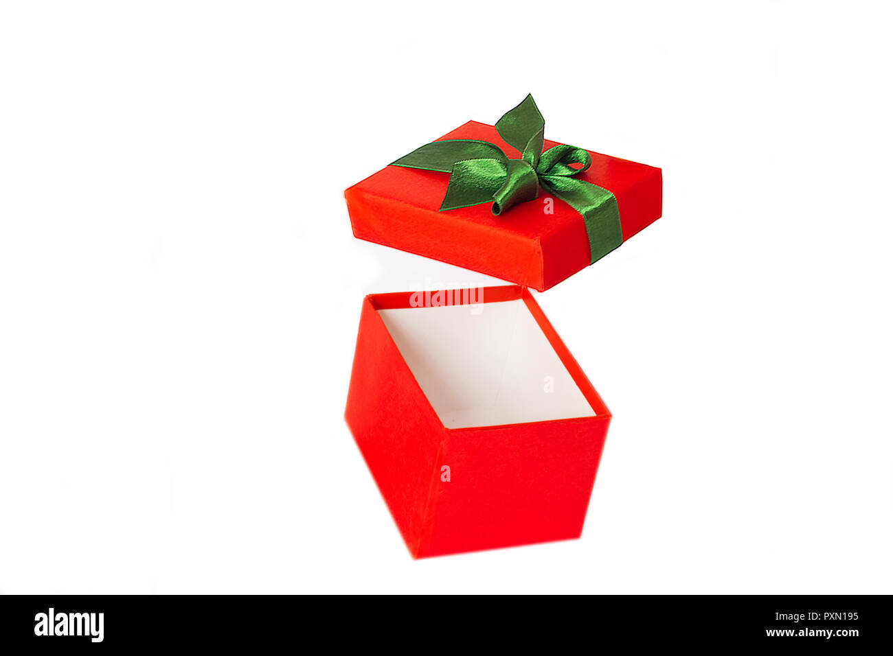 Red gift box with the green satin ribbon and open cover flying on the air Stock Photo