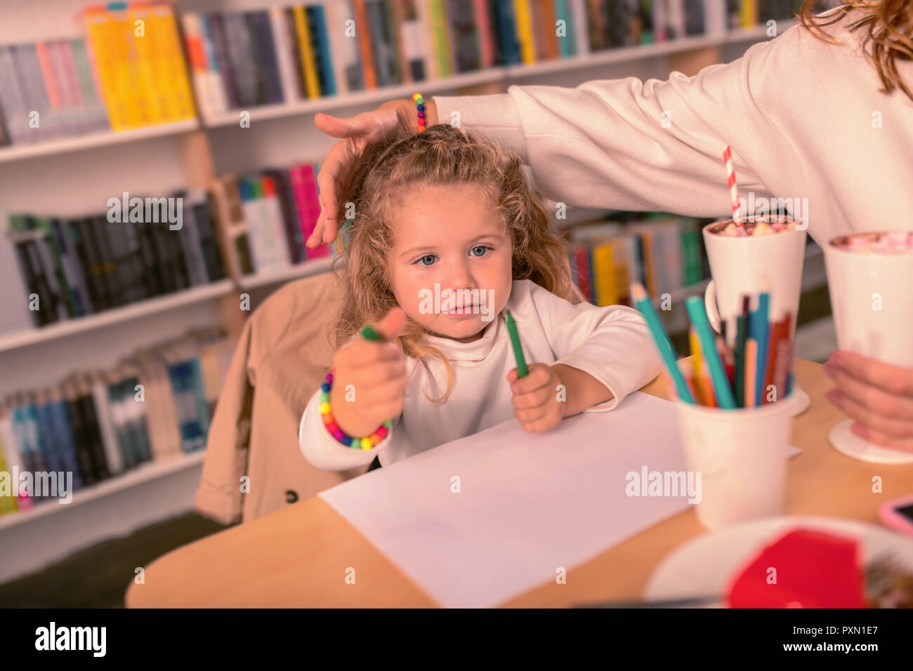 Attentive blonde girl choosing perfect color of pencil Stock Photo