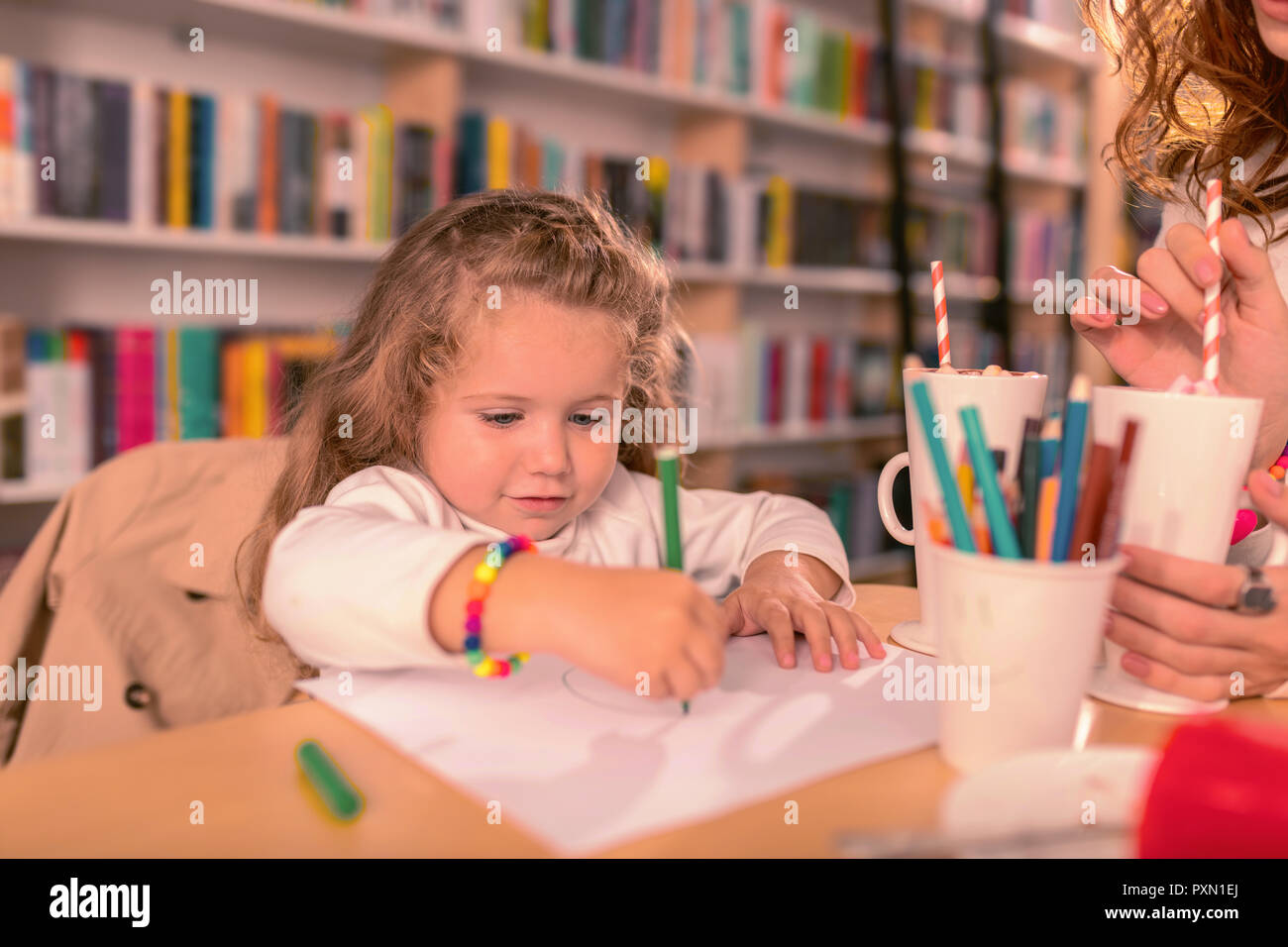 Concentrated child being busy while preparing present for mom Stock Photo