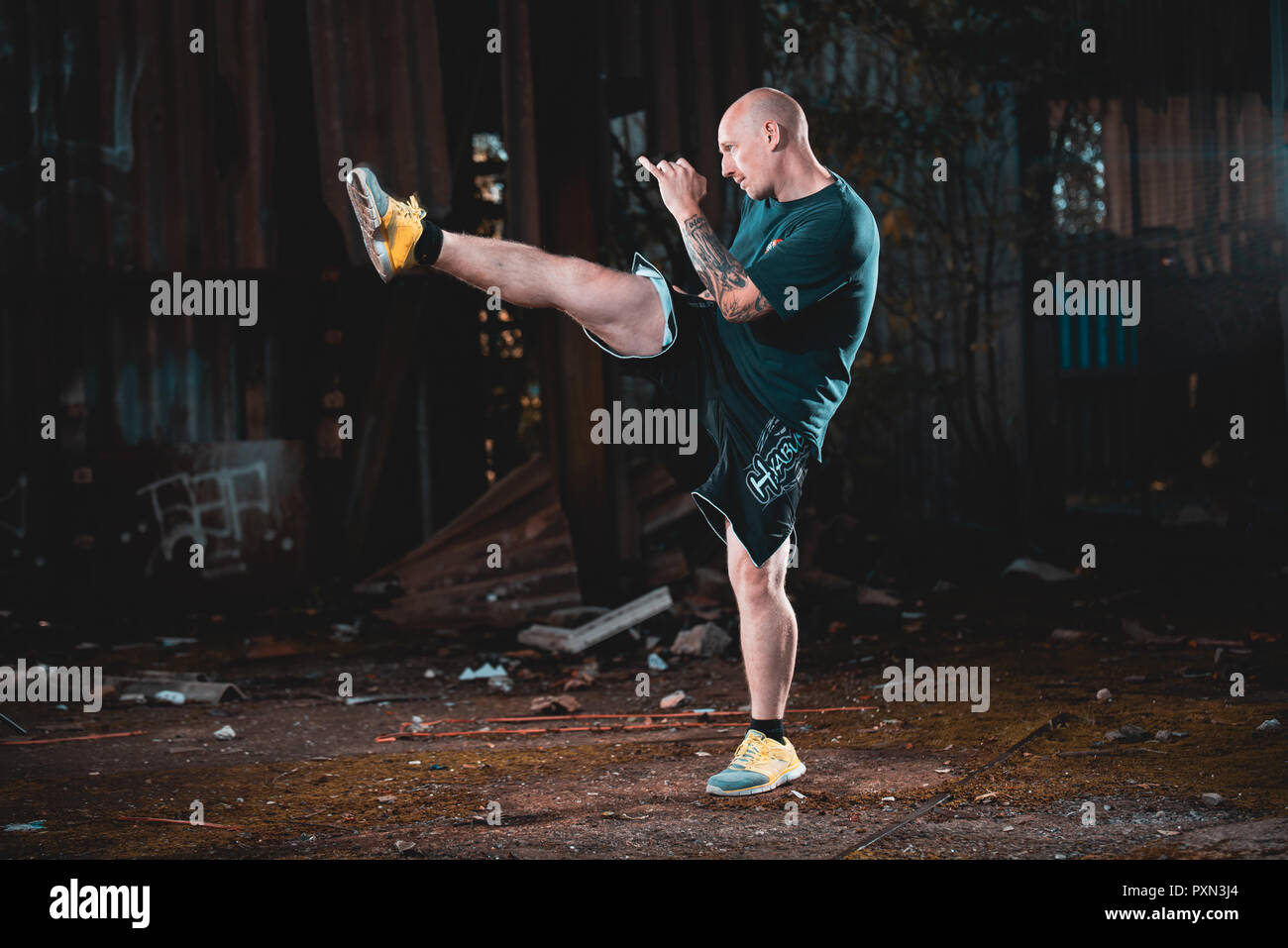Male MMA Martial Artist fighter performing a kick Stock Photo