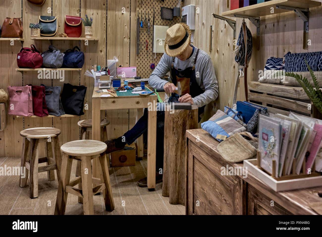 Leather shop wooden interior with shopkeeper at work Stock Photo