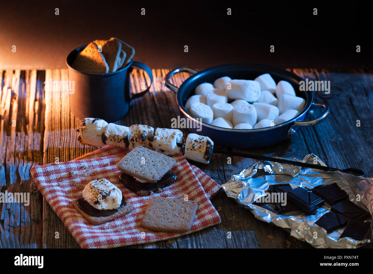 S'mores still life on a wooden table with marshmallow, chocolate and graham crackers, all gluten free products. Stock Photo