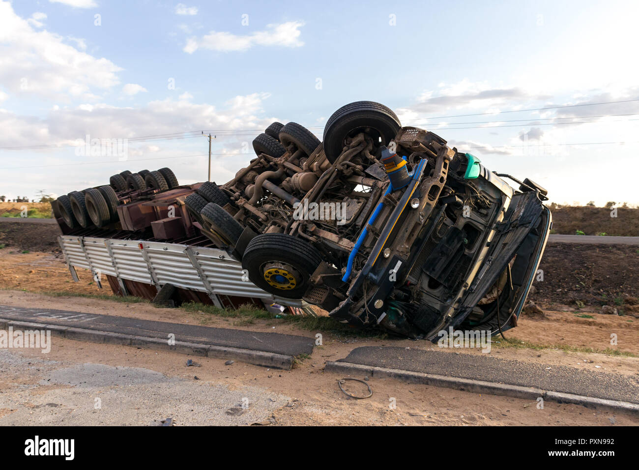 An overturned lorry by the side of the road with wheels in the air, Mombasa road, Kenya Stock Photo