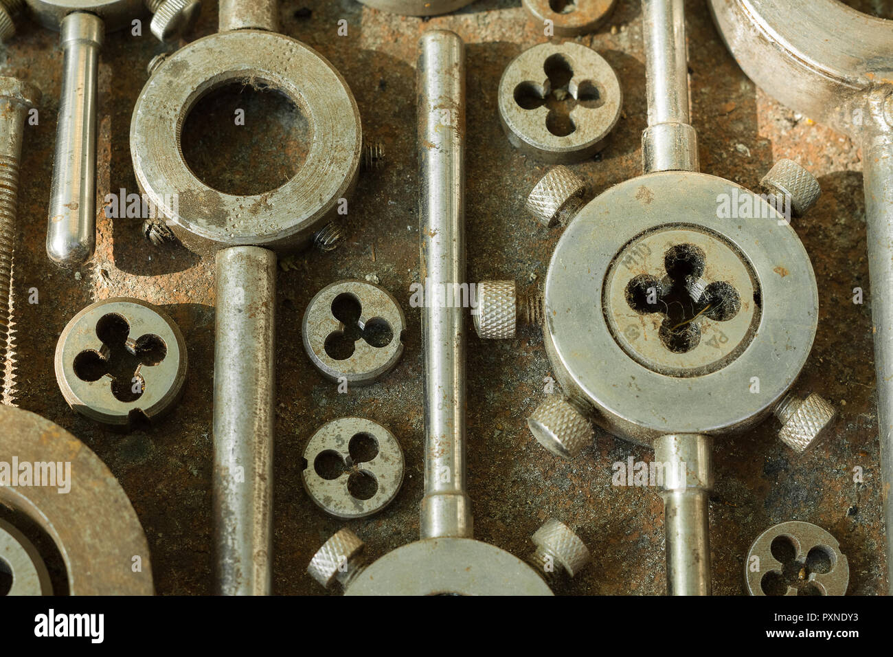 Threading dies on rusty metal surface close-up Stock Photo