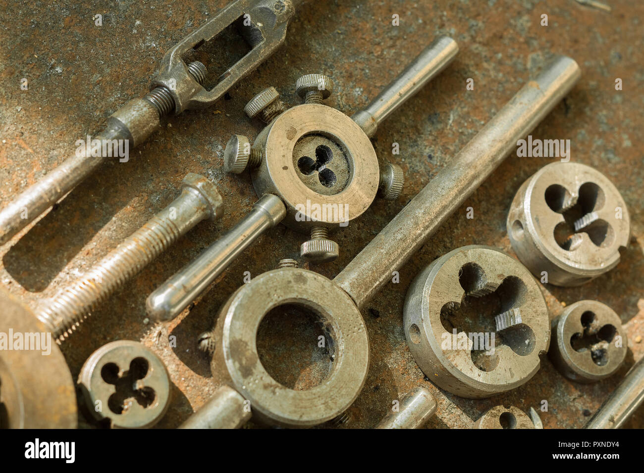 Threading dies on rusty metal surface close-up Stock Photo