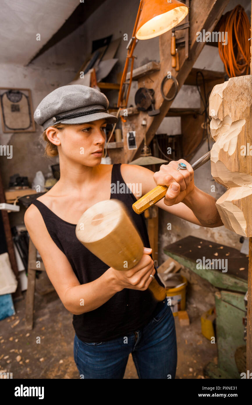 Sculptress carving wooden figure Stock Photo