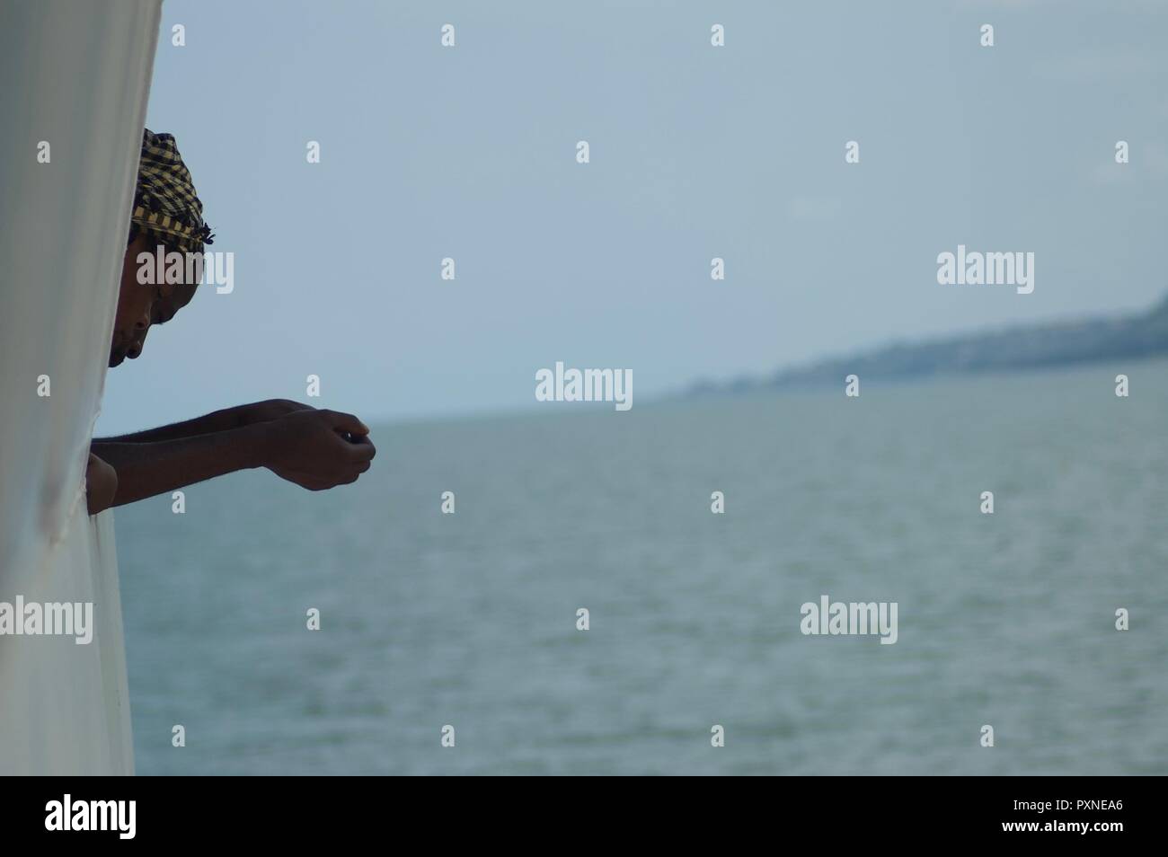 Donkorkrom, Ghana: July 20th 2016 - Outline of lady looking over the side of the Yapei Queen on Lake Volta, Ghana Stock Photo