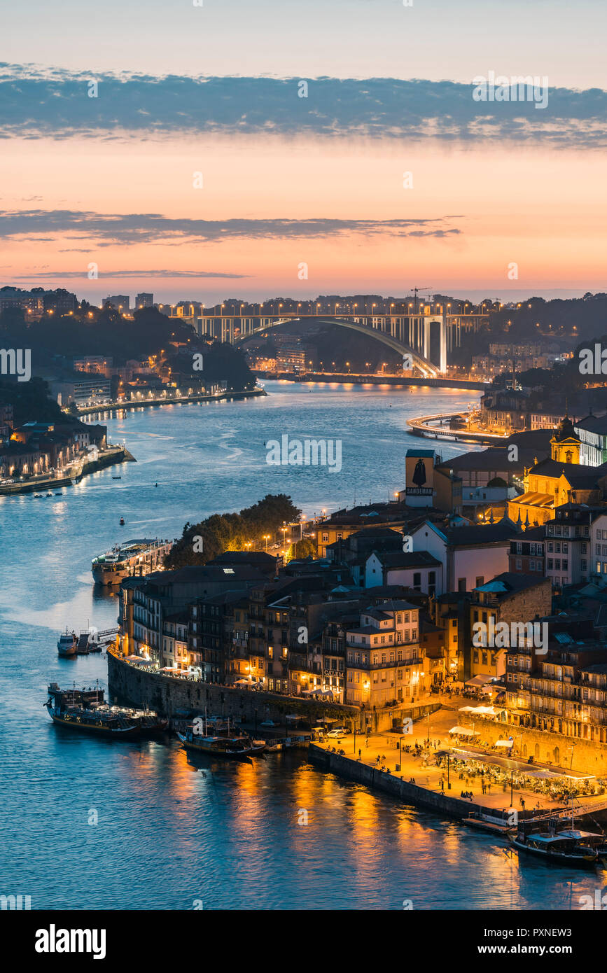 Portugal, Norte region, Porto (Oporto). Douro river banks at dusk with Arrabida bridge in the background. Stock Photo