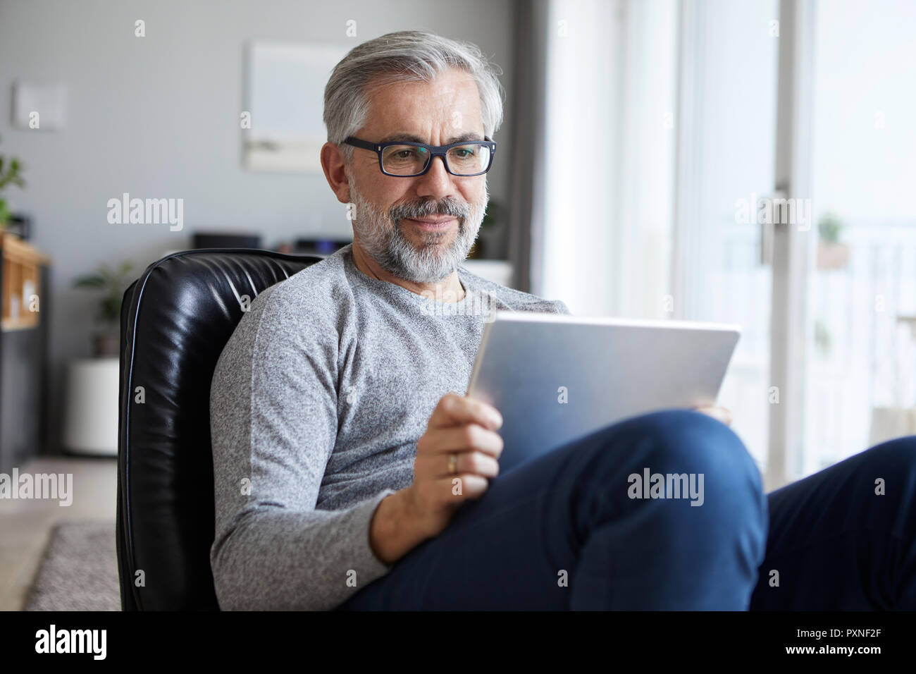 Portrait of mature man using tablet at home Stock Photo