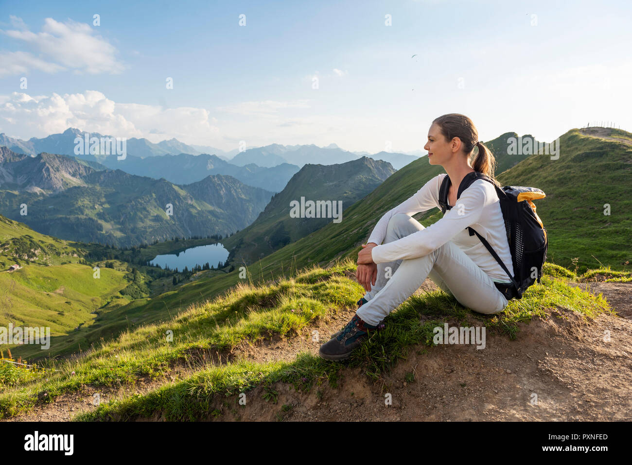 Germany, Bavaria, Oberstdorf, woman on a hike in the mountains having a break Stock Photo