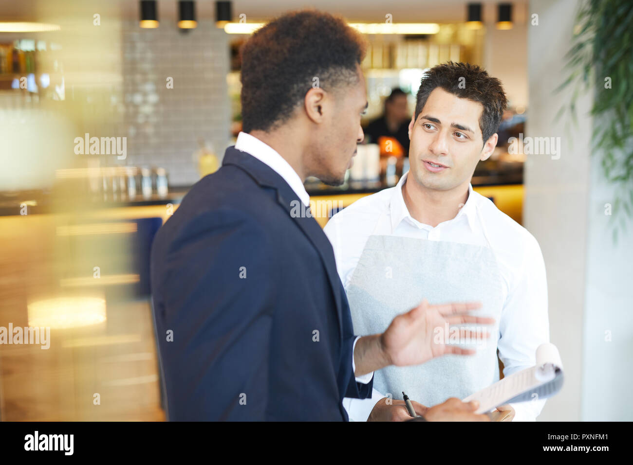 Young restaurant manager gives instructions to the waiter in the restaurant Stock Photo