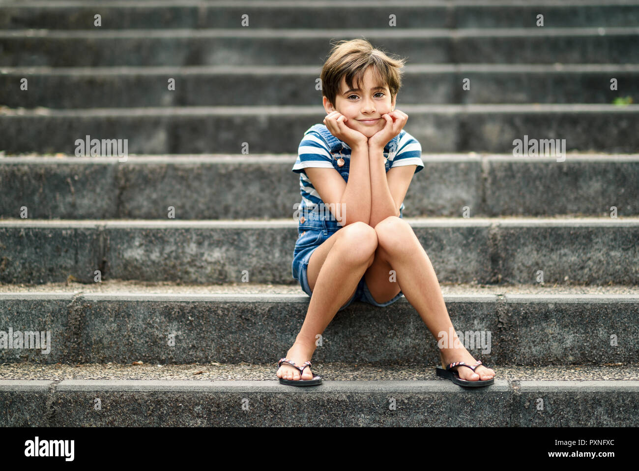 Portrait of relaxed little girl sitting on stairs Stock Photo