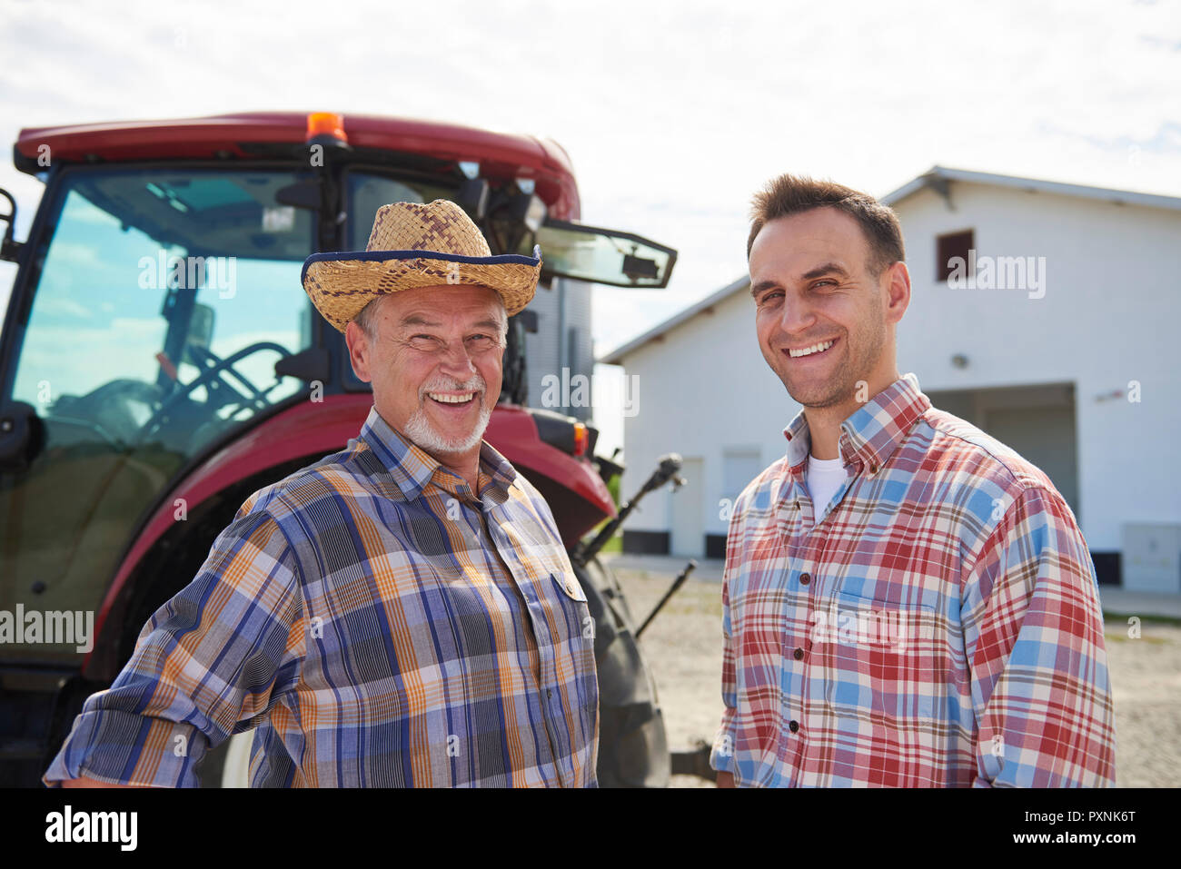 Portrait of two farmers in front of the barn Stock Photo - Alamy