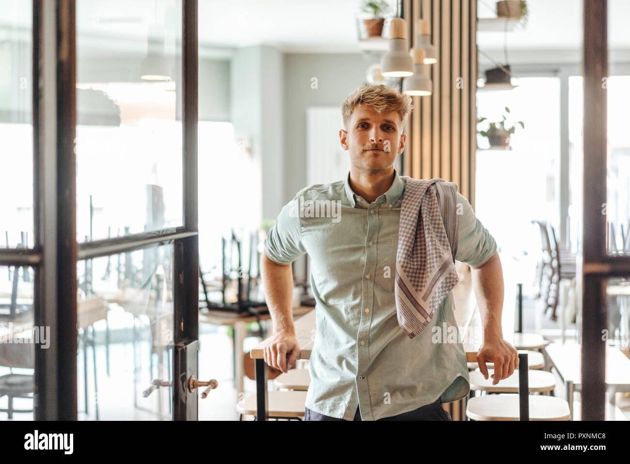 Young man working in his start-up cafe, portrait Stock Photo