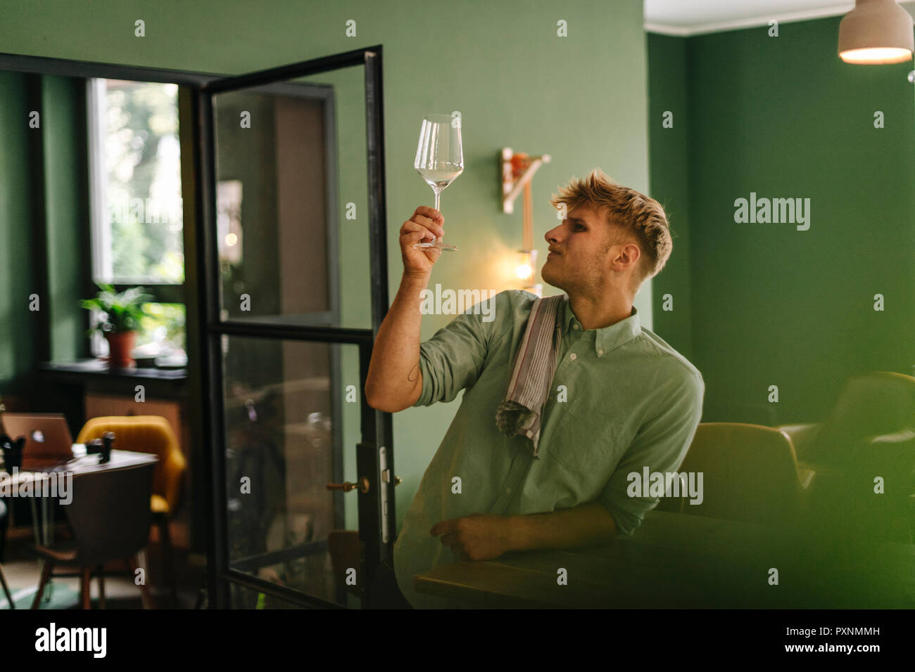 Young business owner checking wine glass in his restaurant Stock Photo