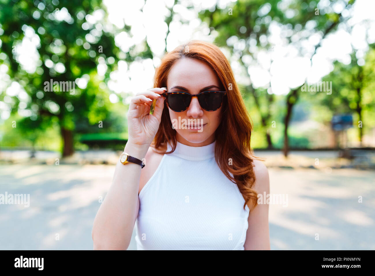 Portrait of redheaded woman wearing sunglasses Stock Photo