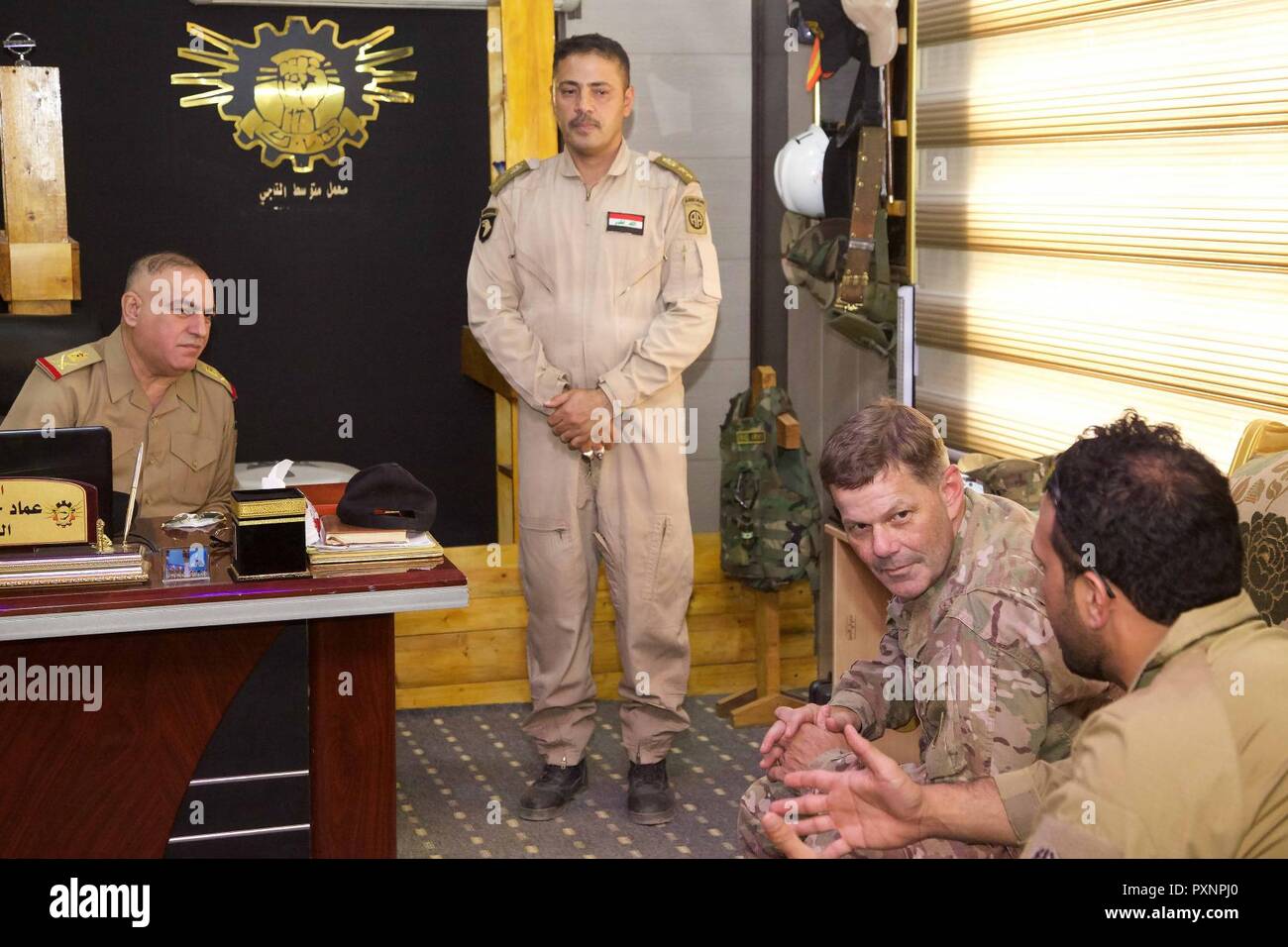 U.S. Army Maj. Gen. Flem Walker, commanding general, 1st Sustainment Command (Theater) and the deputy commanding general-sustainment for United States Army Central, visits Iraqi Army Staff Maj. Gen. Hassan(left) commander of the Electrical Mechanical Engineering Directorate, and Colonel Ahmad(middle), commander of the Taji Level III Wheeled Vehicle Facility, at Camp Taji, Iraq, June 17, 2017. Walker's purpose is to get an overview of the U.S. Army Logistic capability after taking command on May 15, 2017. His visit will assist in increasing partner forces capability as an integral part of the C Stock Photo