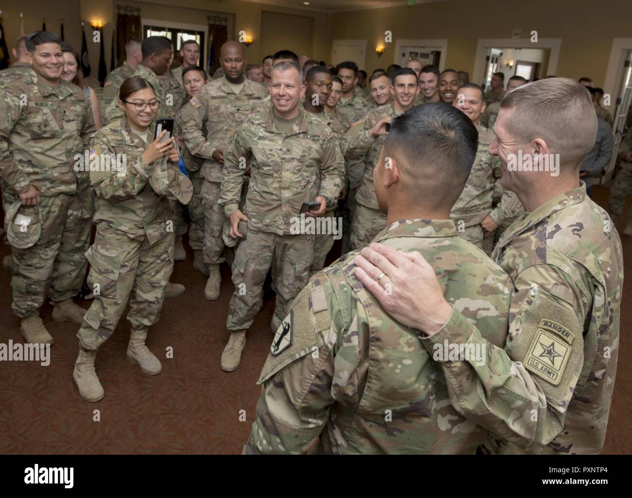 Soldiers wait to have their photo taken with Sgt. Maj. of the Army Daniel Dailey, right, after a town hall at Fort Irwin, Calif., June 8, 2017. Dailey, who has an outgoing and approachable personality, makes it a priority to meet with Soldiers and hear their concerns wherever he goes. Stock Photo