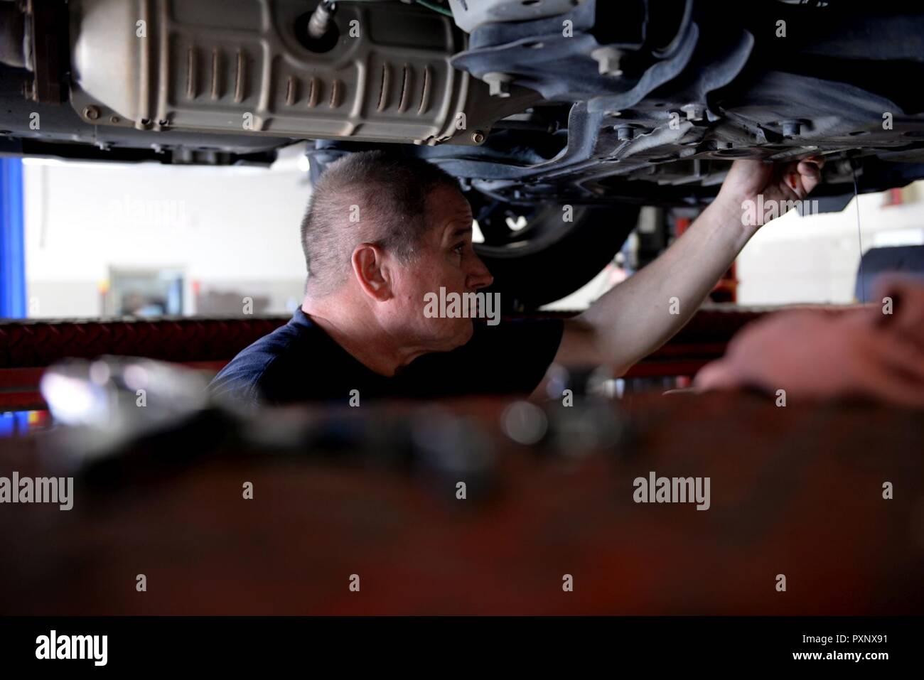Thomas Johnson, 19th Force Support Squadron Auto Hobby Shop lead mechanic, finishes draining the oil of a customer’s car June 9, 2017, at Little Rock Air Force Base, Ark. Johnson uses a variety of tools to help make draining oil from cars easier. Stock Photo
