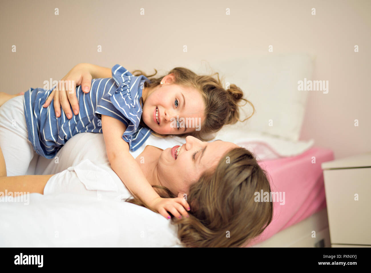 Mother and daughter enjoy in bed at home Stock Photo