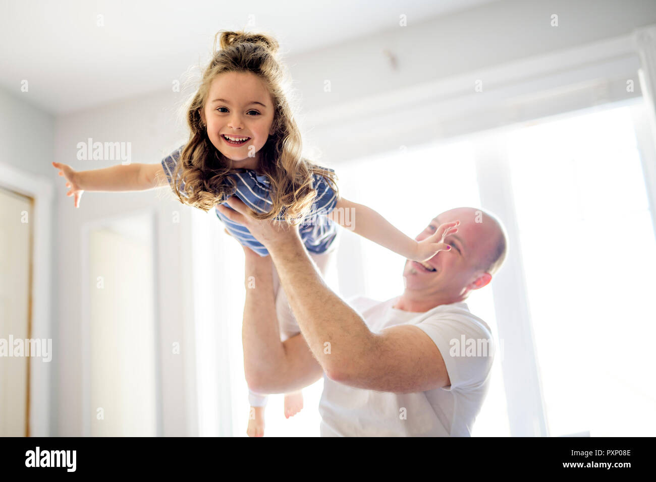 Happy father and daughter having fun together on a bed Stock Photo - Alamy