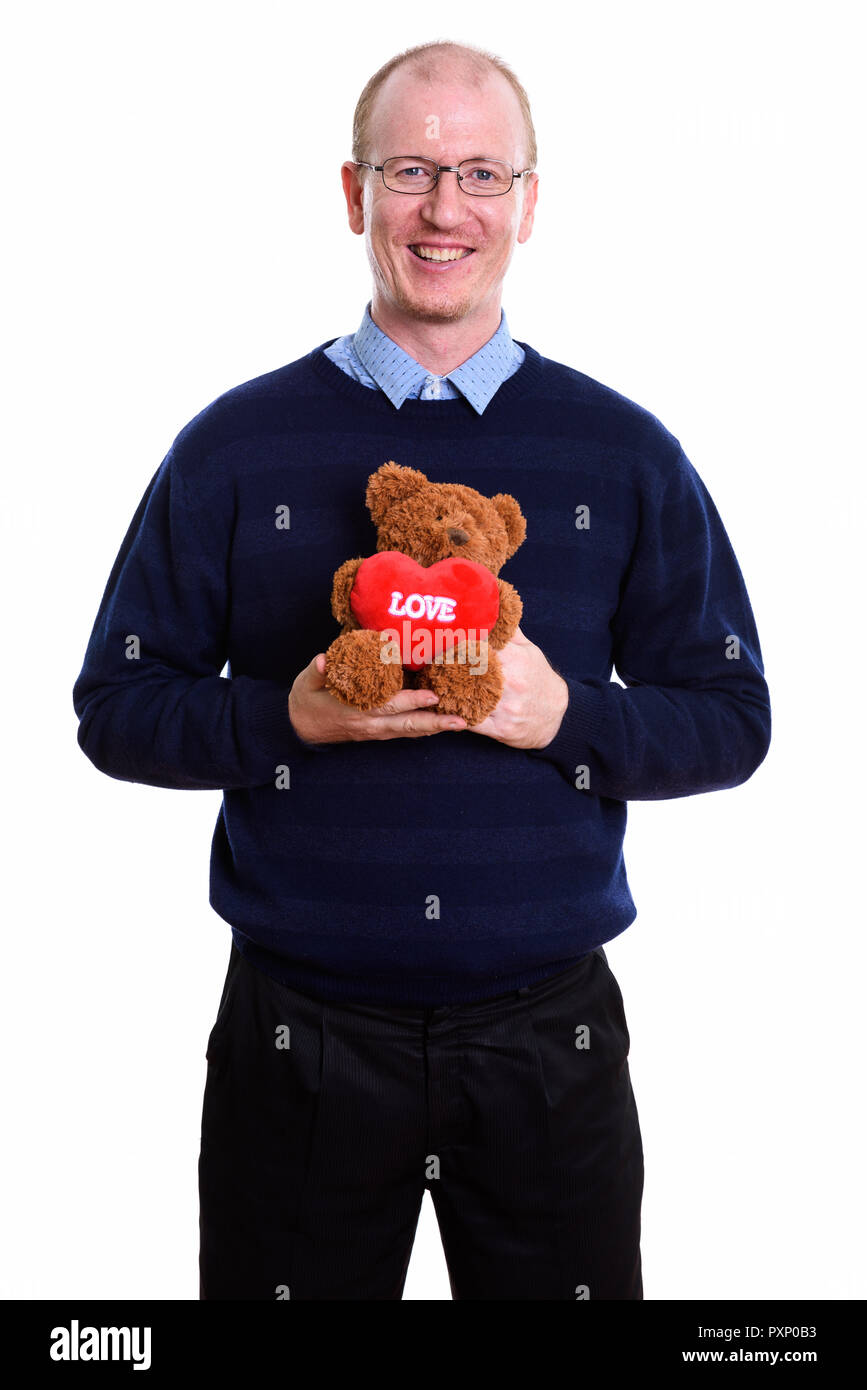 Happy man smiling while holding teddy bear with heart and love s Stock Photo