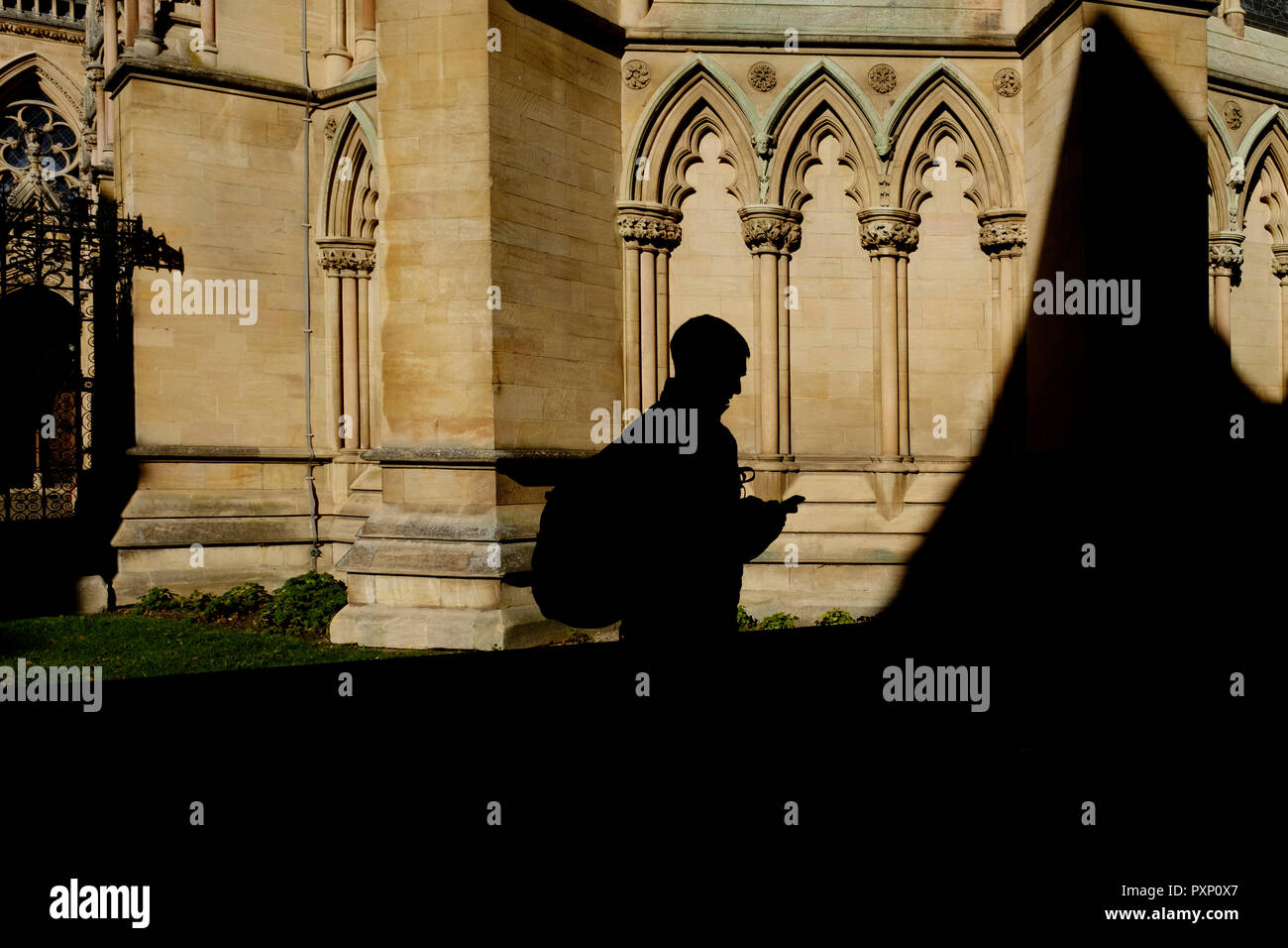 A silhouette of a person walking infront of St John's college Chapel, St John's Street, Cambridge, UK Stock Photo