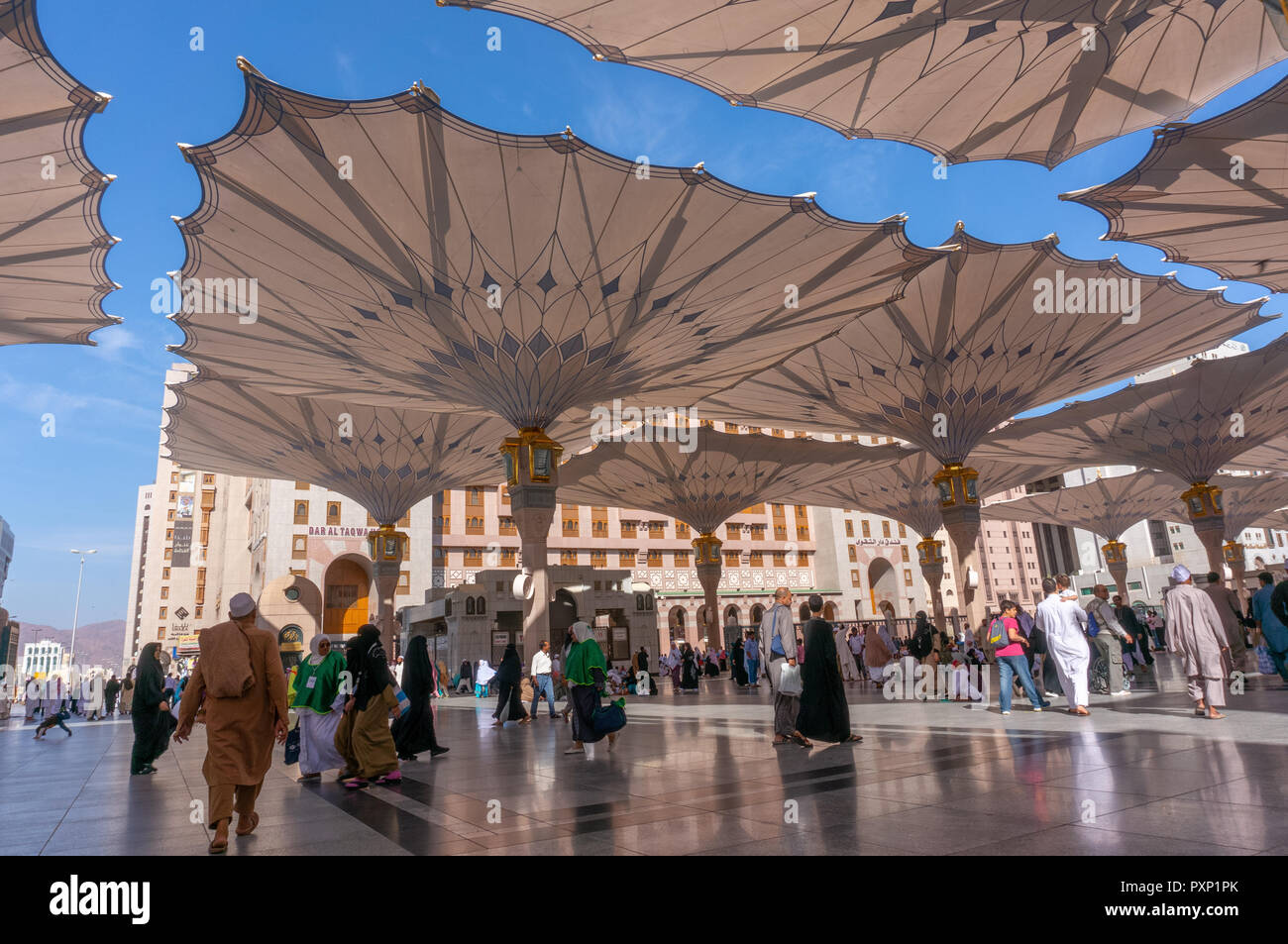 MEDINA,SAUDI ARABIA- CIRCA 2014 : view of giant canopies and pilgrims at Masjid Nabawi (Mosque) compound in Medina, Kingdom of Saudi Arabia. Nabawi mo Stock Photo