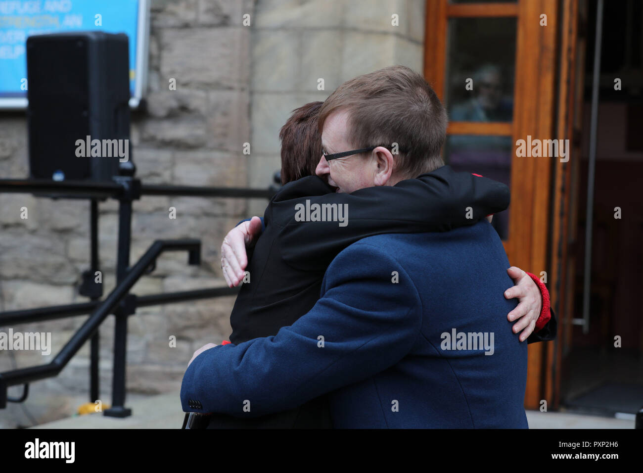 Michelle Williamson hugs Willie Frazer outside West Kirk Presbyterian Church in Belfast for a service to mark the 25th anniversary of the IRA bombing of a fish shop on Shankill Road. Stock Photo