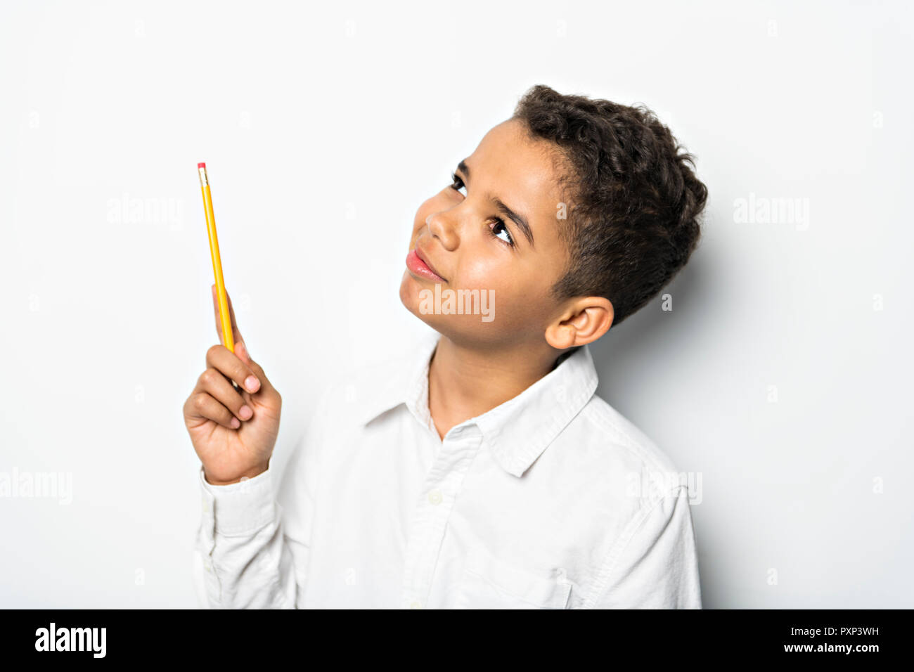 A Black boy holding school pensil over white background Stock Photo