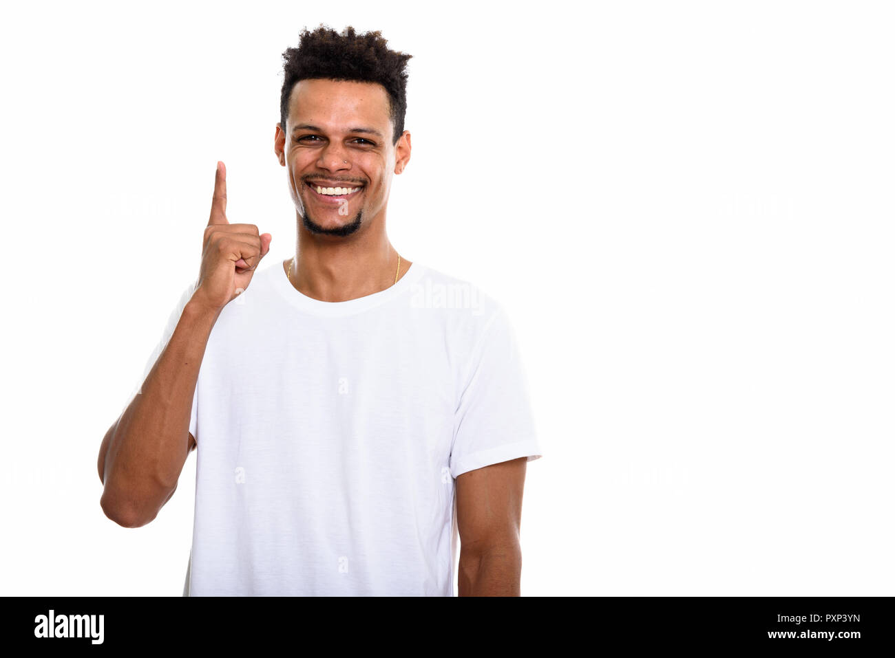 Studio shot of young happy African man smiling while pointing fi Stock Photo