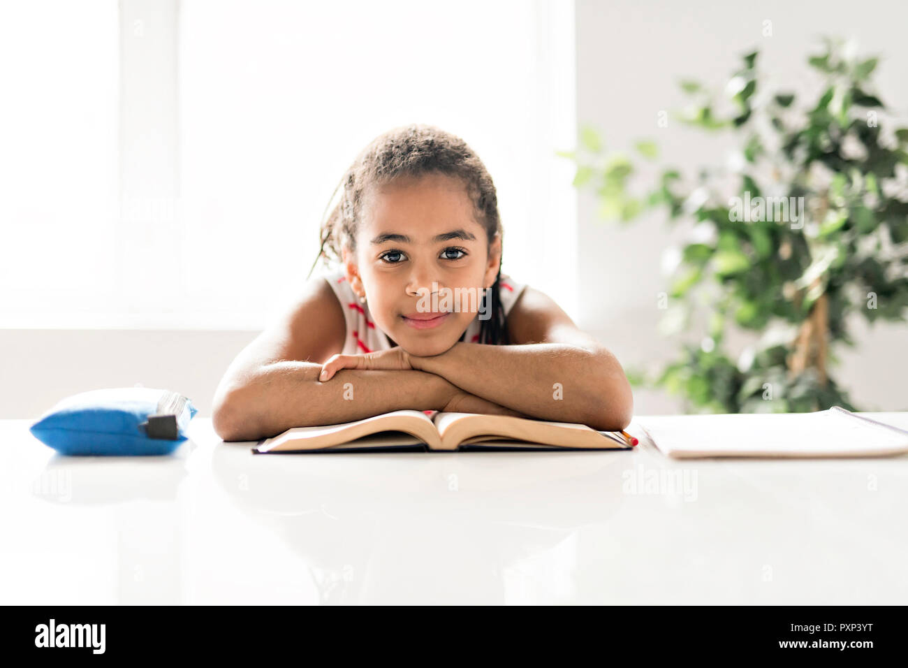 A cute Black girl doing homework at home Stock Photo
