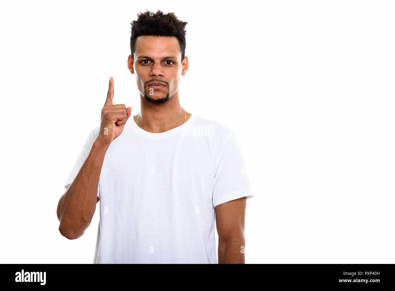 Studio shot of young African man pointing finger up Stock Photo