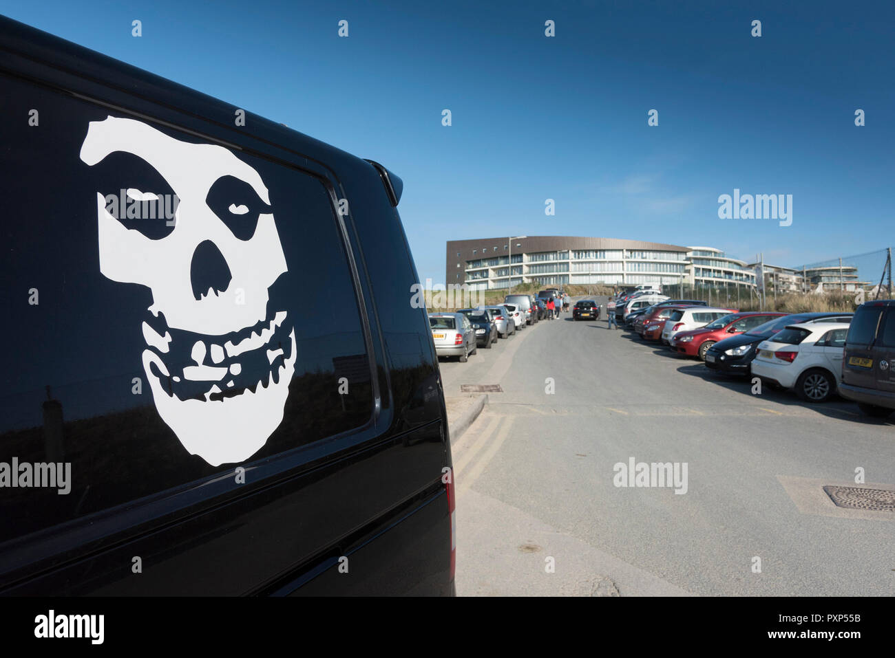 A white skull motif artwork on the side of a black van in the car park at Fistral in Newquay in Cornwall. Stock Photo