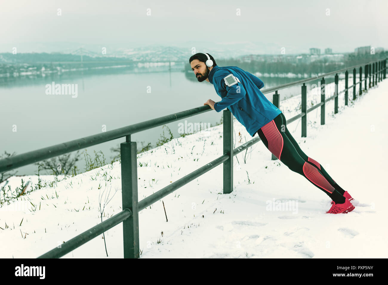 Young man athlete doing push ups and doing exercises during the winter ...