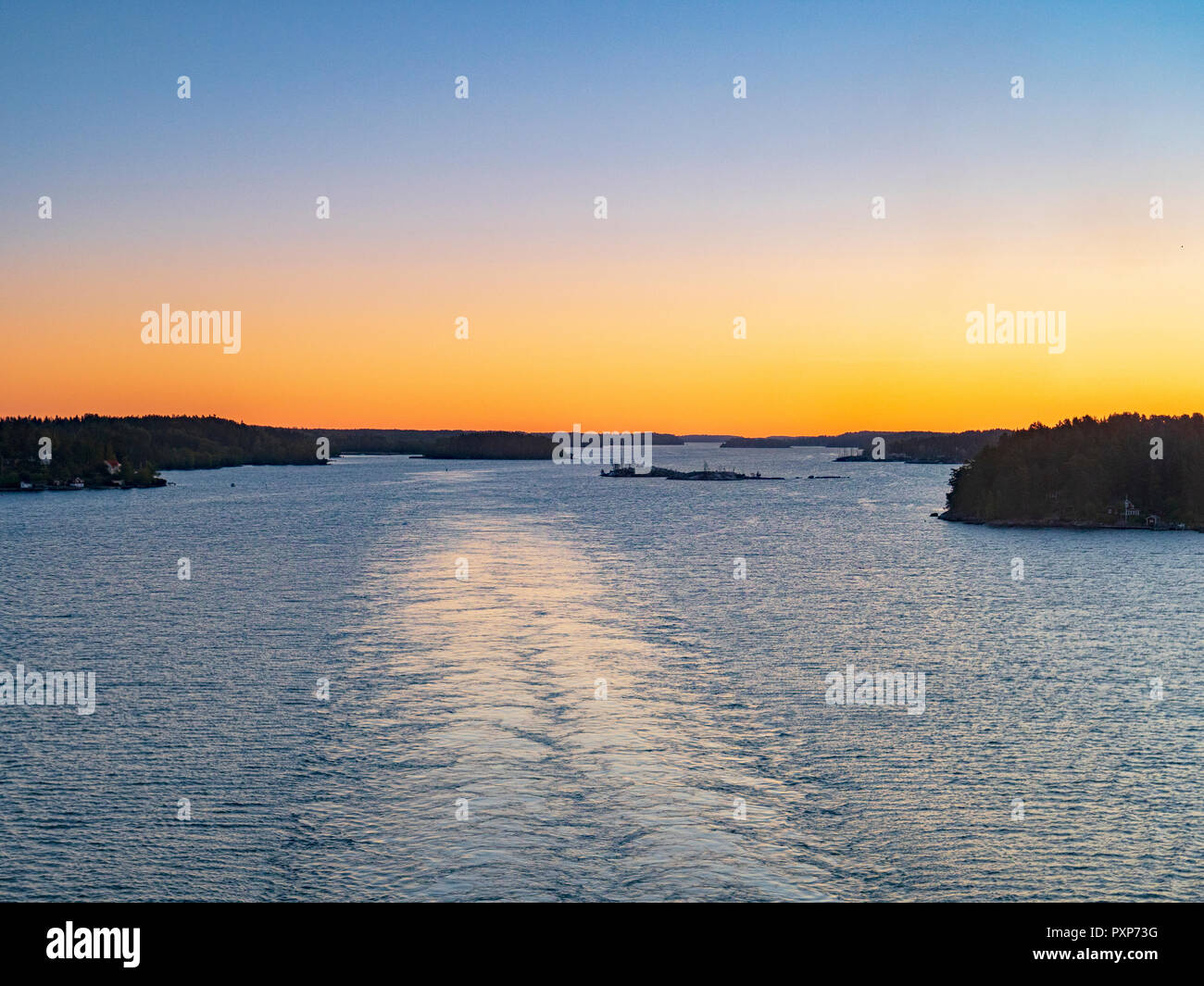 The wake of a cruise liner sailing into port through the Stockholm Archipelago. Stock Photo