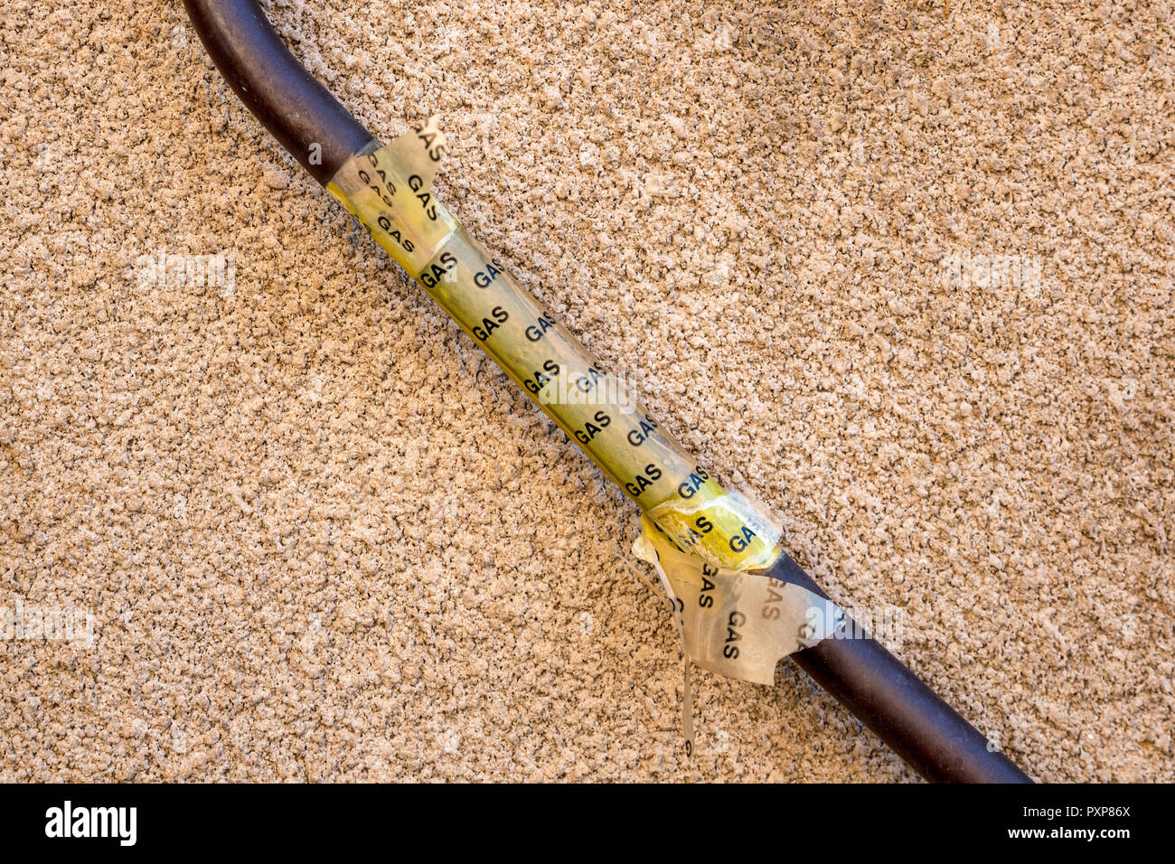 domestic gas supply pipe outside of traditional british house with text