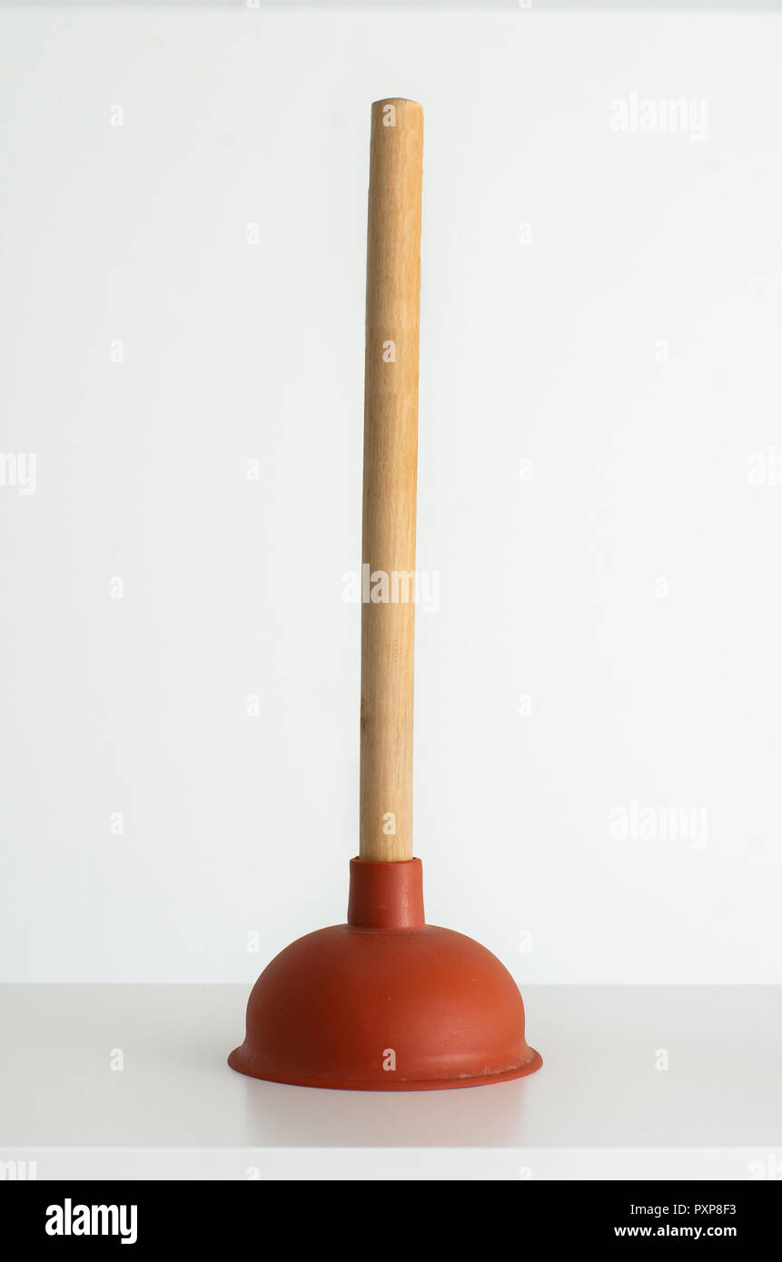 Red plunger with wooden grip against bright white background Stock Photo