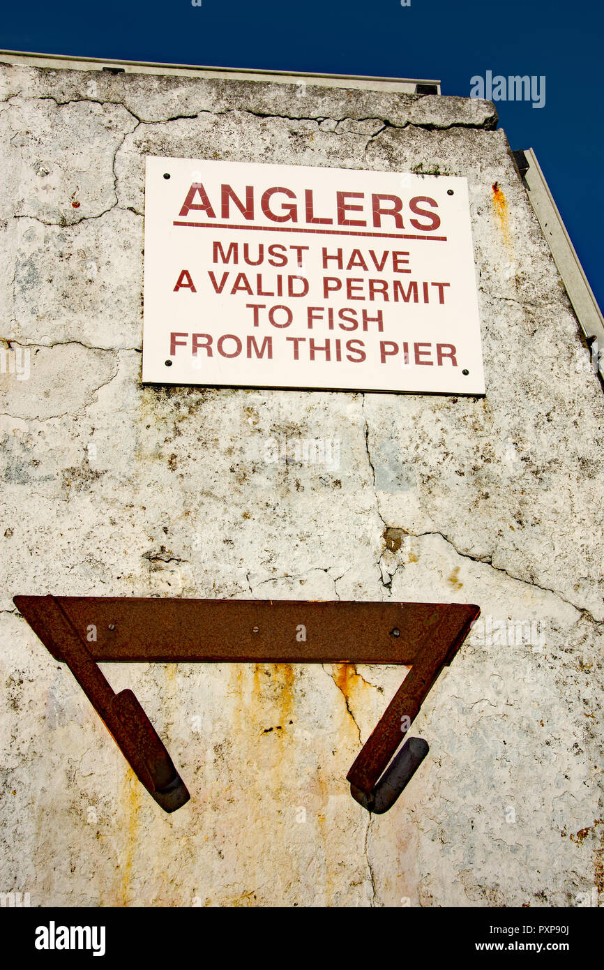 warning sign for anglers fixed to a white painted wall Stock Photo