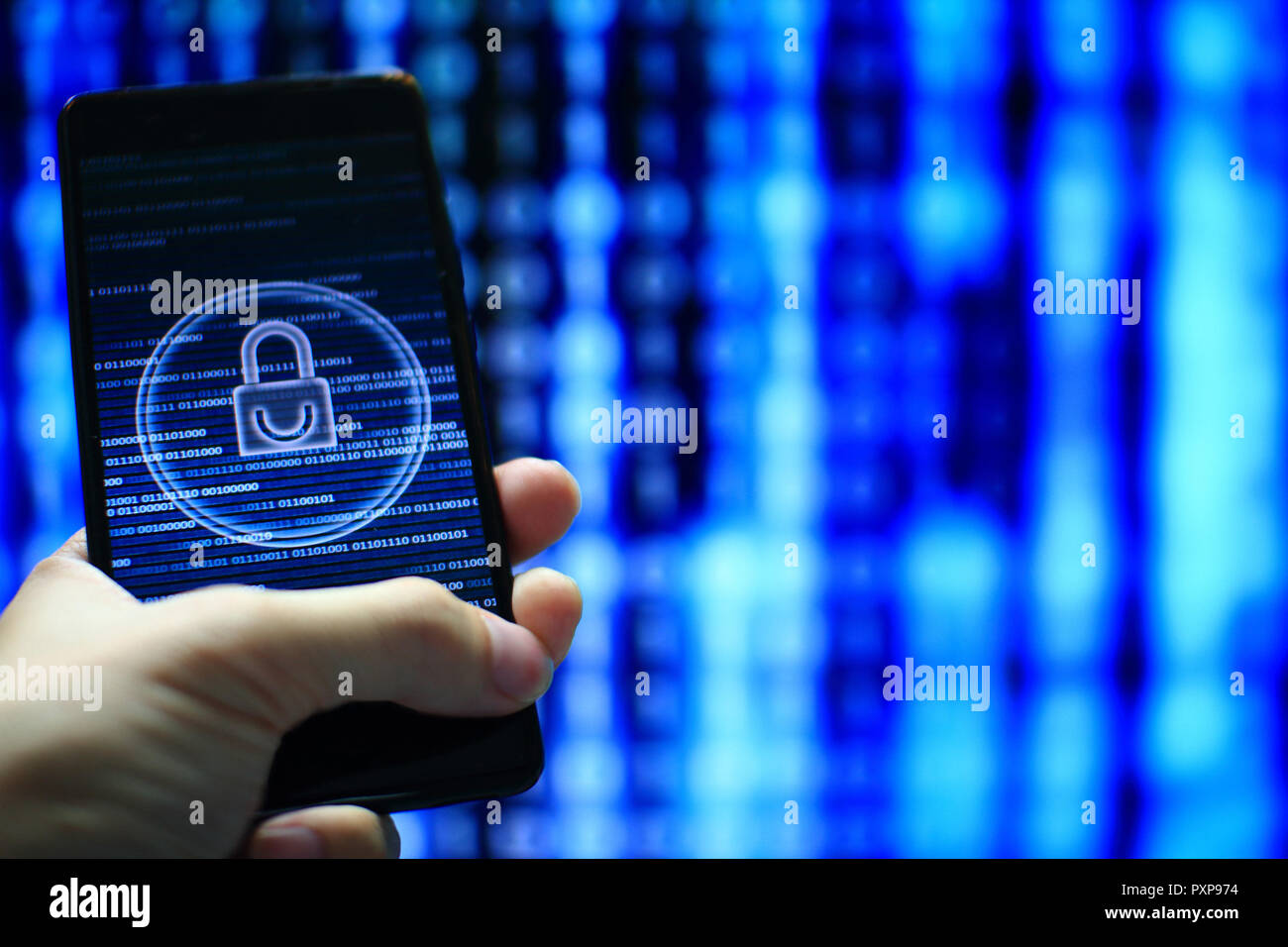 hand hold mobile phone flow. padlock icon symbolize security and motion movement of blue binary code computer data moving in the background. Stock Photo