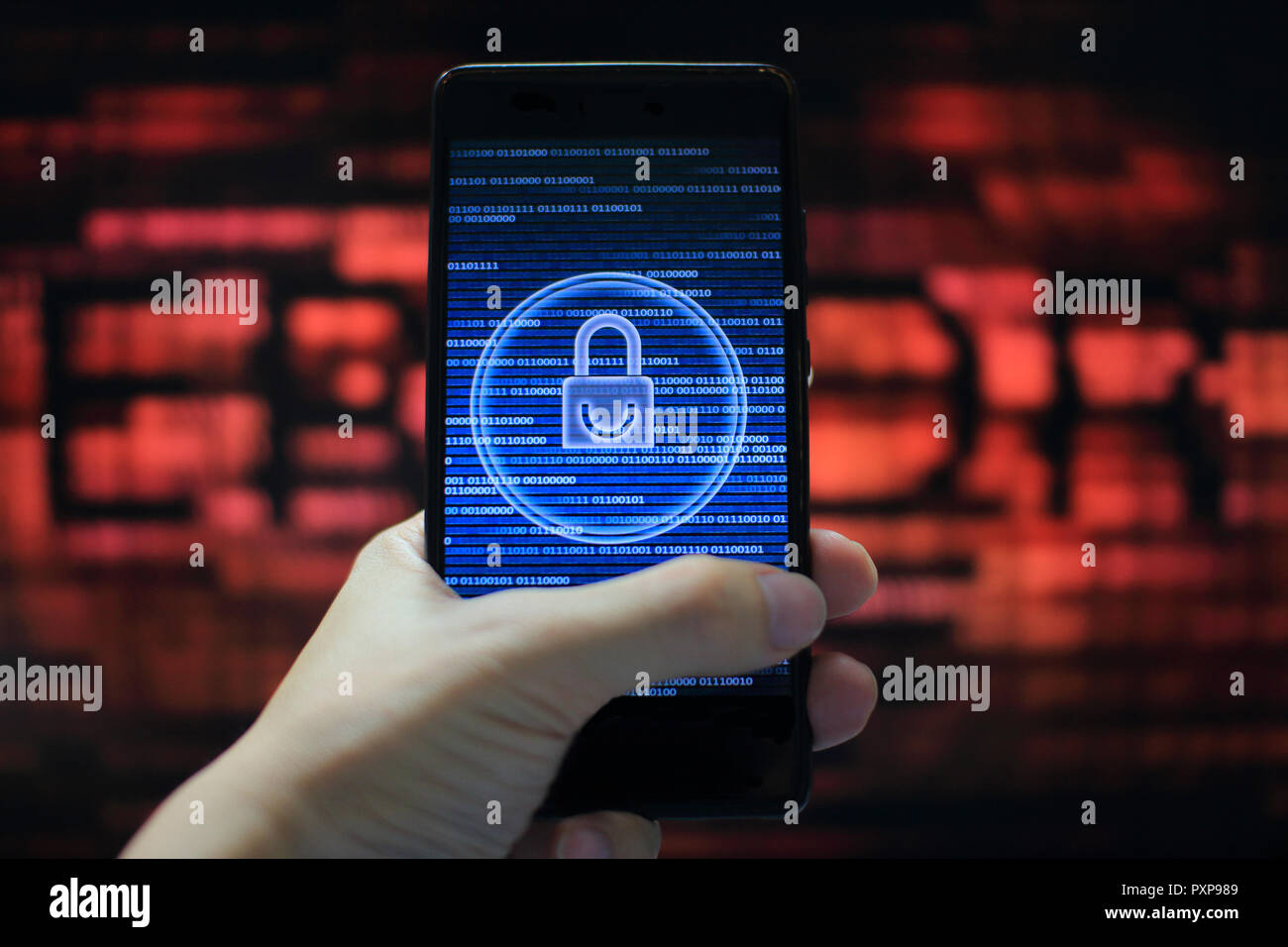 system integrity working while other pass down. hand holding mobile phone with padlock icon on blue binary code screen. Error message in computer. Stock Photo