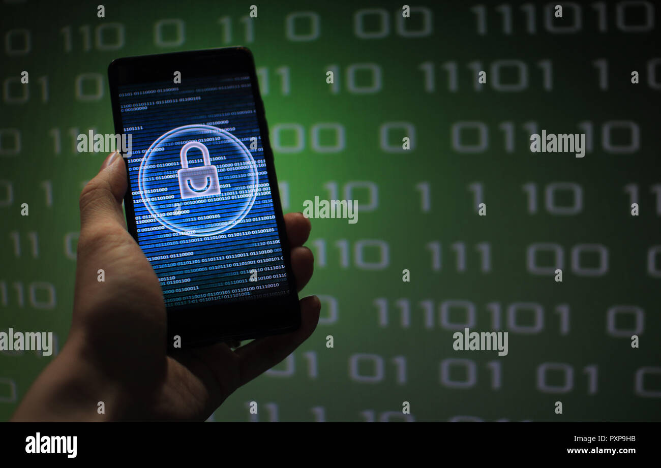protected in stream of data flow. padlock icon symbolize security and Green binary code computer data in the background. hand holding mobile phone. Stock Photo