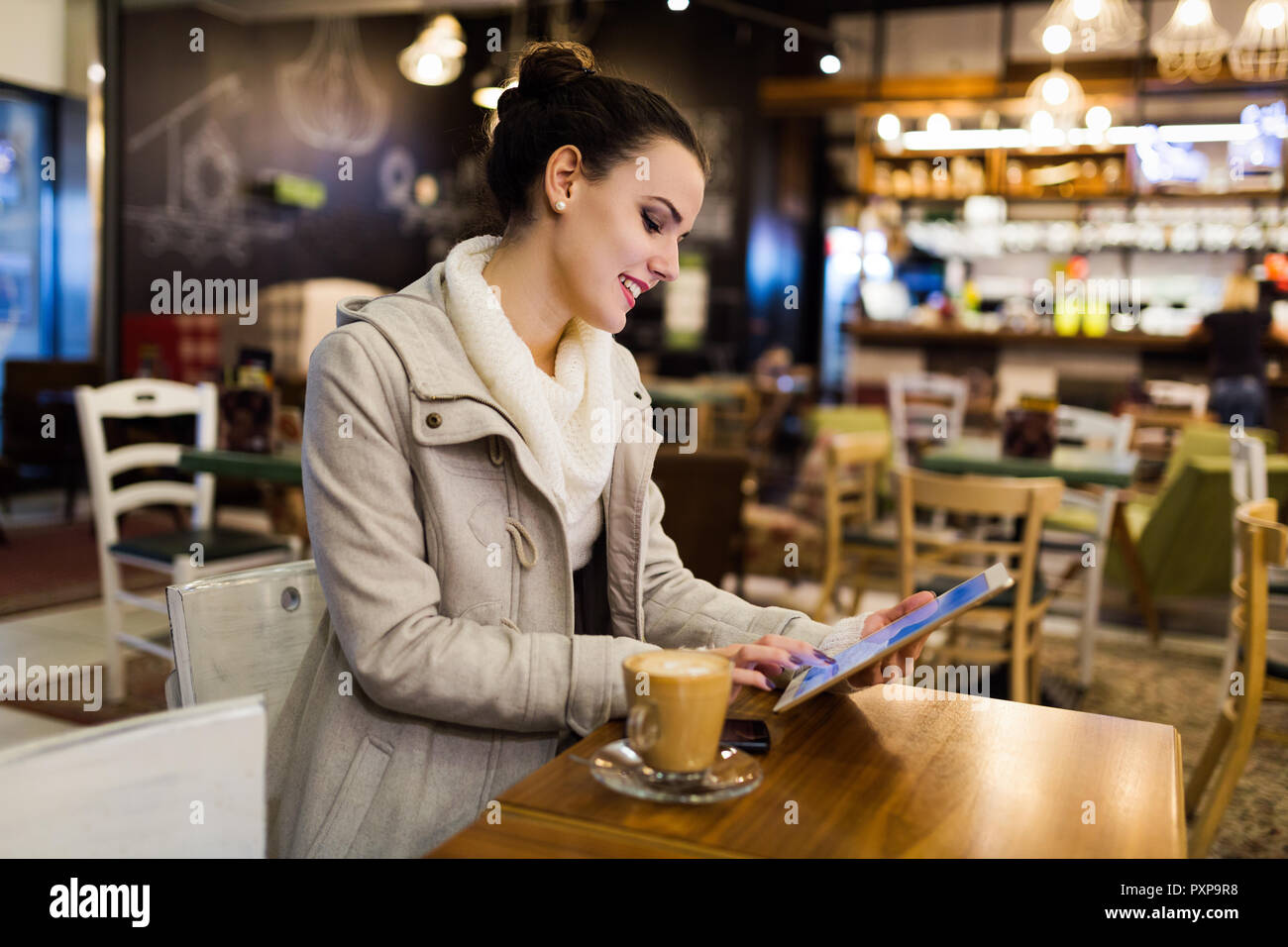 Attractive young woman using tablet in cafe Stock Photo