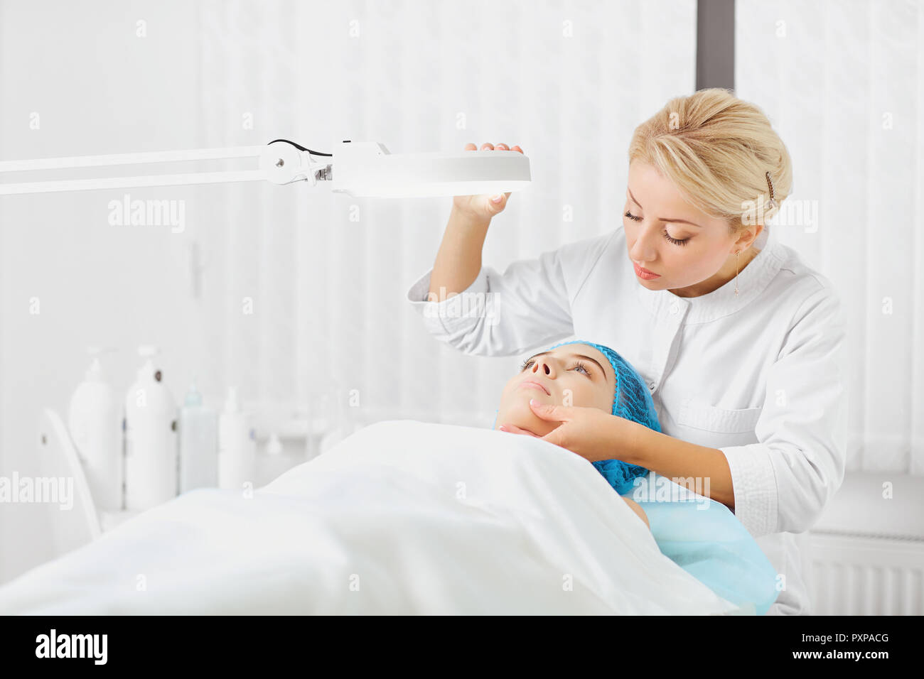 A female dermatologist examines the face of a girl. Stock Photo