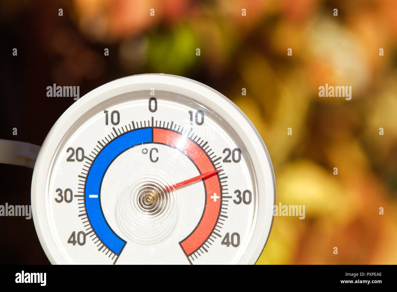 Outdoor thermometer with celsius scale showing warm temperature hot