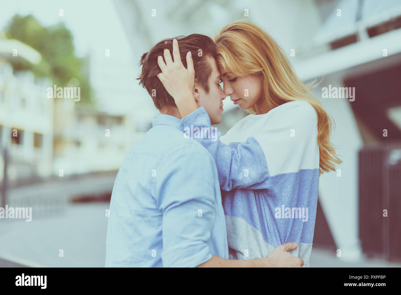 Beautiful couple in love dating outdoors and smiling. Beautiful girl embraces the guy Stock Photo