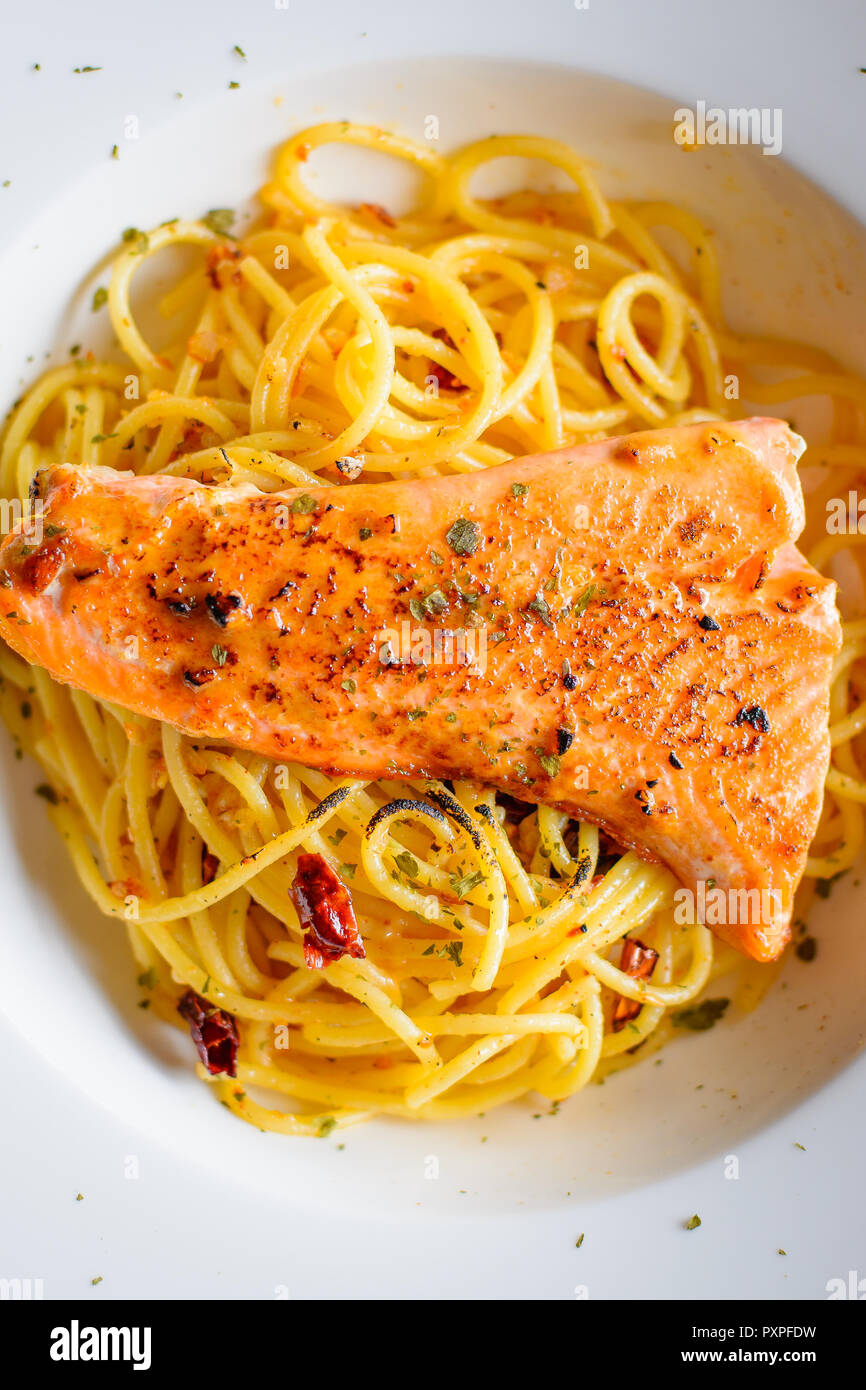 grilled Salmon with Aglio Olio spaghetti with herb Stock Photo - Alamy