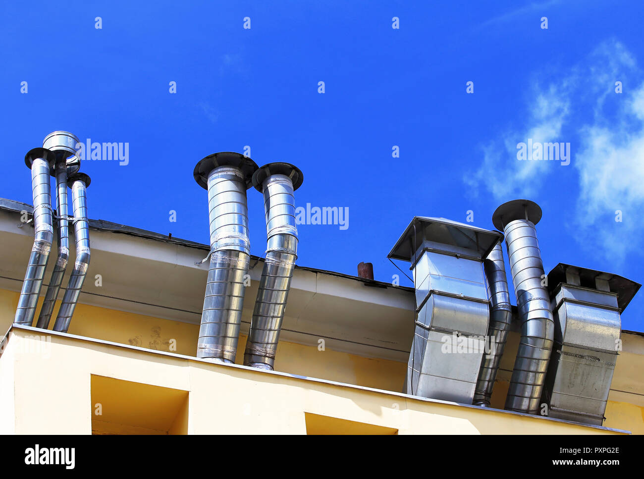 Ventilation pipes and actuators on the roof of building Stock Photo